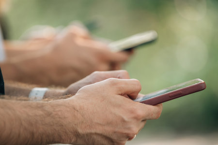 close-up of group of hands of young people with mobile phonesの写真素材