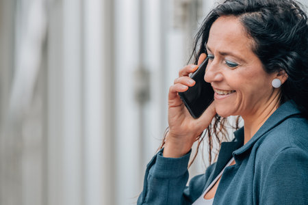 portrait of business woman in the street talking on mobile phone