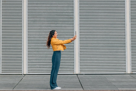full body woman on the street with mobile phone