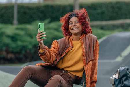 girl on the street in autumn with mobile phoneの写真素材