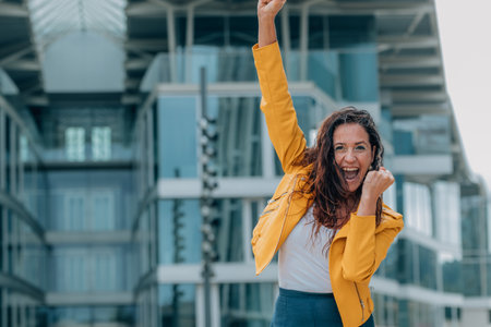 middle-aged woman on the street with euphoric expression of success and joyの写真素材