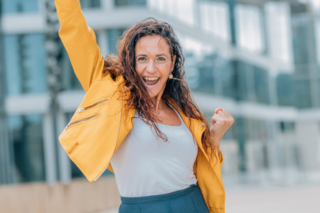middle-aged woman on the street with euphoric expression of success and joyの写真素材