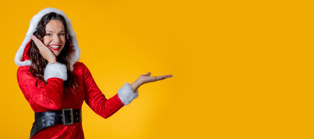 young woman wearing santa claus costume isolated pointingの写真素材