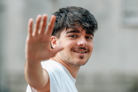 portrait of young man waving smiling