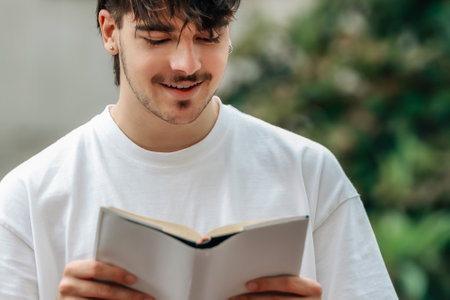 young man with book on the street outdoorsの写真素材