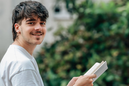 young man with book on the street outdoors