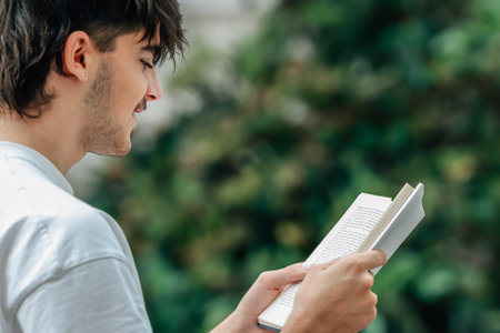 young man with book on the street outdoorsの写真素材
