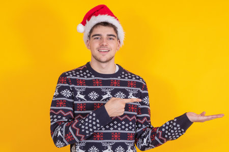 isolated young man or teenager with santa claus hat and christmas sweaterの写真素材