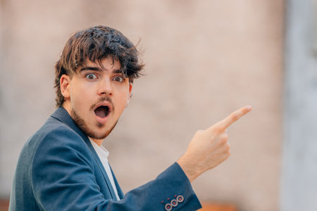 young man or student pointing surprisedの写真素材