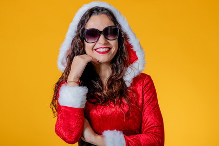 young woman wearing santa claus suit isolated with sunglassesの写真素材