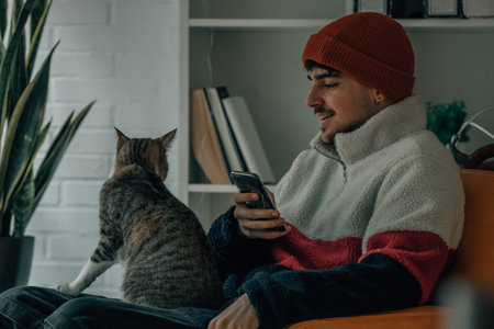 young man at home with pet catの写真素材