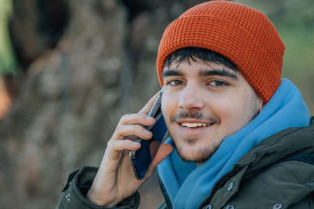 young man bundled up in winter talking on mobile phoneの写真素材
