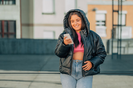 girl with jacket outdoors with mobile phoneの写真素材