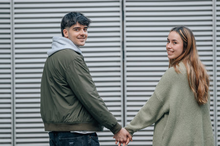 young couple on the street holding handsの写真素材