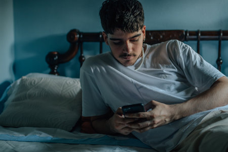 young man at home with mobile phone or smartphoneの写真素材