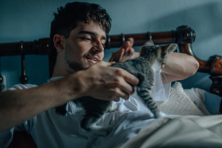 young man at home playing with petの写真素材