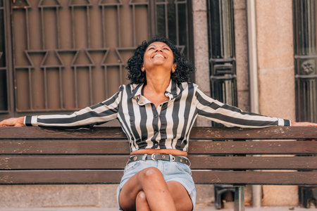 happy woman sitting on the street benchの写真素材