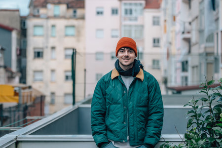 portrait of young man on the street in winter warm and wearing a hat