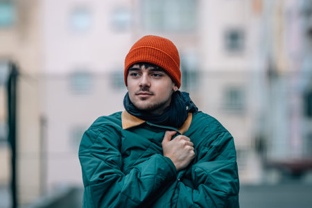 portrait of young man on the street in winter warm and wearing a hat