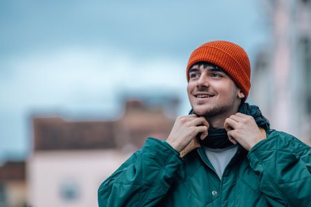 portrait of young man on the street in winter warm and wearing a hatの写真素材