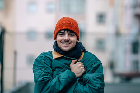 portrait of young man on the street in winter warm and wearing a hat