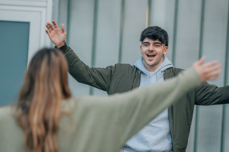 friends greeting each other warmly on the streetの写真素材