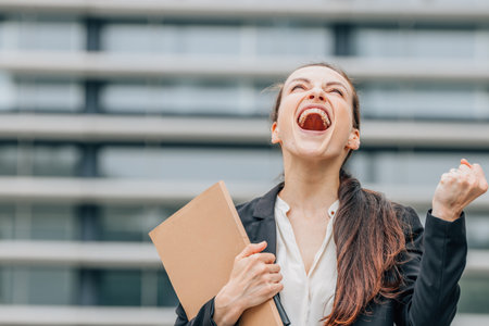 Portrait of a young business woman celebrating success in the city.