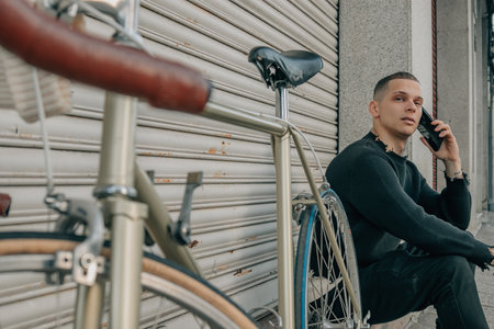 young man sitting on the street with mobile phone