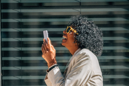 business woman with mobile phone smiling out loudの写真素材
