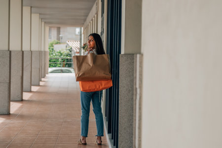 latin girl walking on the street with shopping and shopping bagsの写真素材
