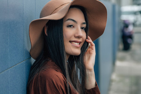 girl with hat talking on mobile phone on the streetの写真素材