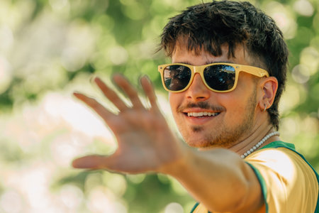 portrait of smiling young man in sunglasses and yellow t-shirt in summerの写真素材