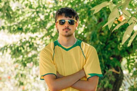 portrait of smiling young man in sunglasses and yellow t-shirt in summer