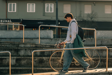 young man or student on the street with vintage bicycle at sunsetの写真素材