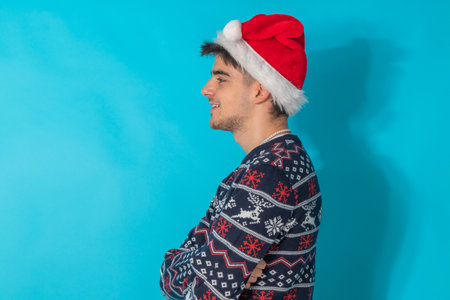 young man with santa claus hat and christmas sweater isolated on background