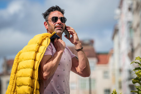 person with sunglasses on the street outdoors with mobile phoneの写真素材