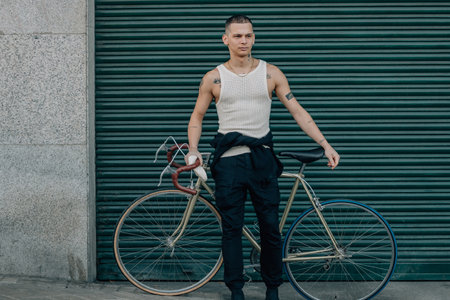 urban young man with bicycle on green street background