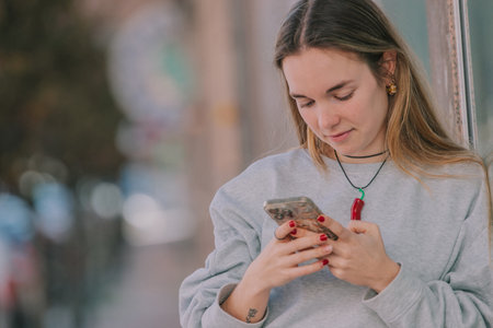 blonde girl on the street outdoors with mobile phone