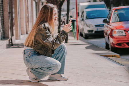 blonde girl on the street outdoors with mobile phoneの写真素材
