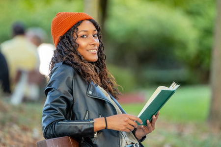 girl in autumn with a textbook on the street outdoorsの写真素材
