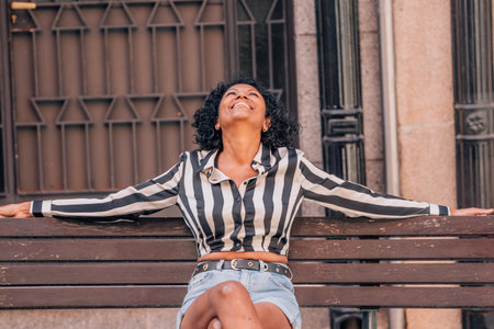 happy woman sitting on the street benchの写真素材