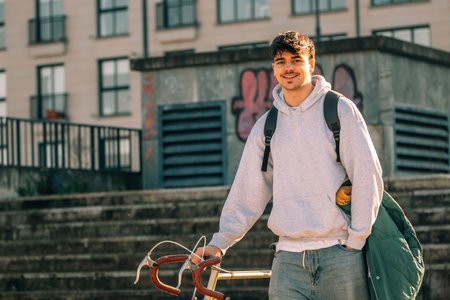 young man or student on the street with vintage bicycle at sunsetの写真素材