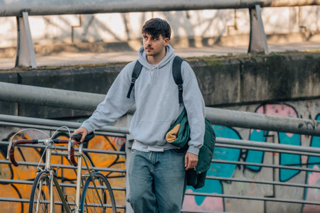 young urban outfit walking with bicycle and backpackの写真素材