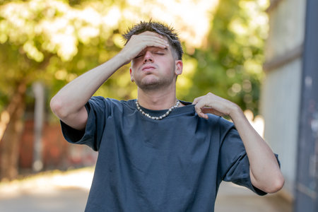 young man or boy with hot expression in summer, heat waveの写真素材