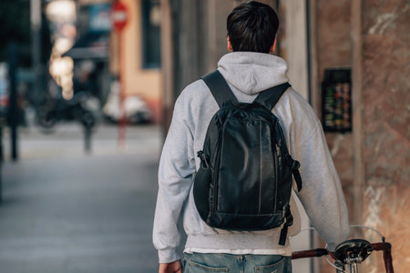 student on the street walking with vintage bicycleの写真素材