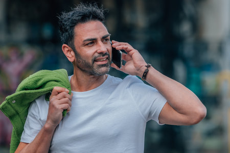 young man calling with mobile phone on streetの写真素材