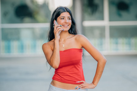 smiling girl in summer clothes on the street talking on the mobile phoneの写真素材