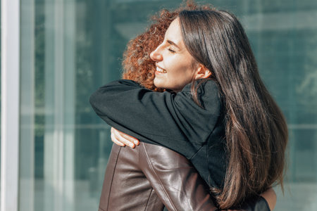 girls hugging in the street showing friendshipの写真素材