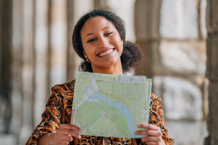 smiling latina girl traveling with map on the streetの写真素材