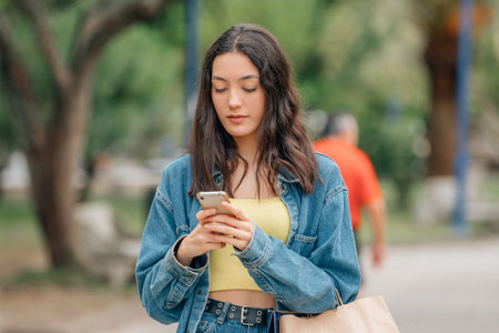 girl walking on the street looking at mobile phone